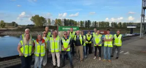 Groepsfoto van de gemeenteraad van Doesburg in gele CTD-hesjes op de kade van Container Terminal Doesburg tijdens het werkbezoek.